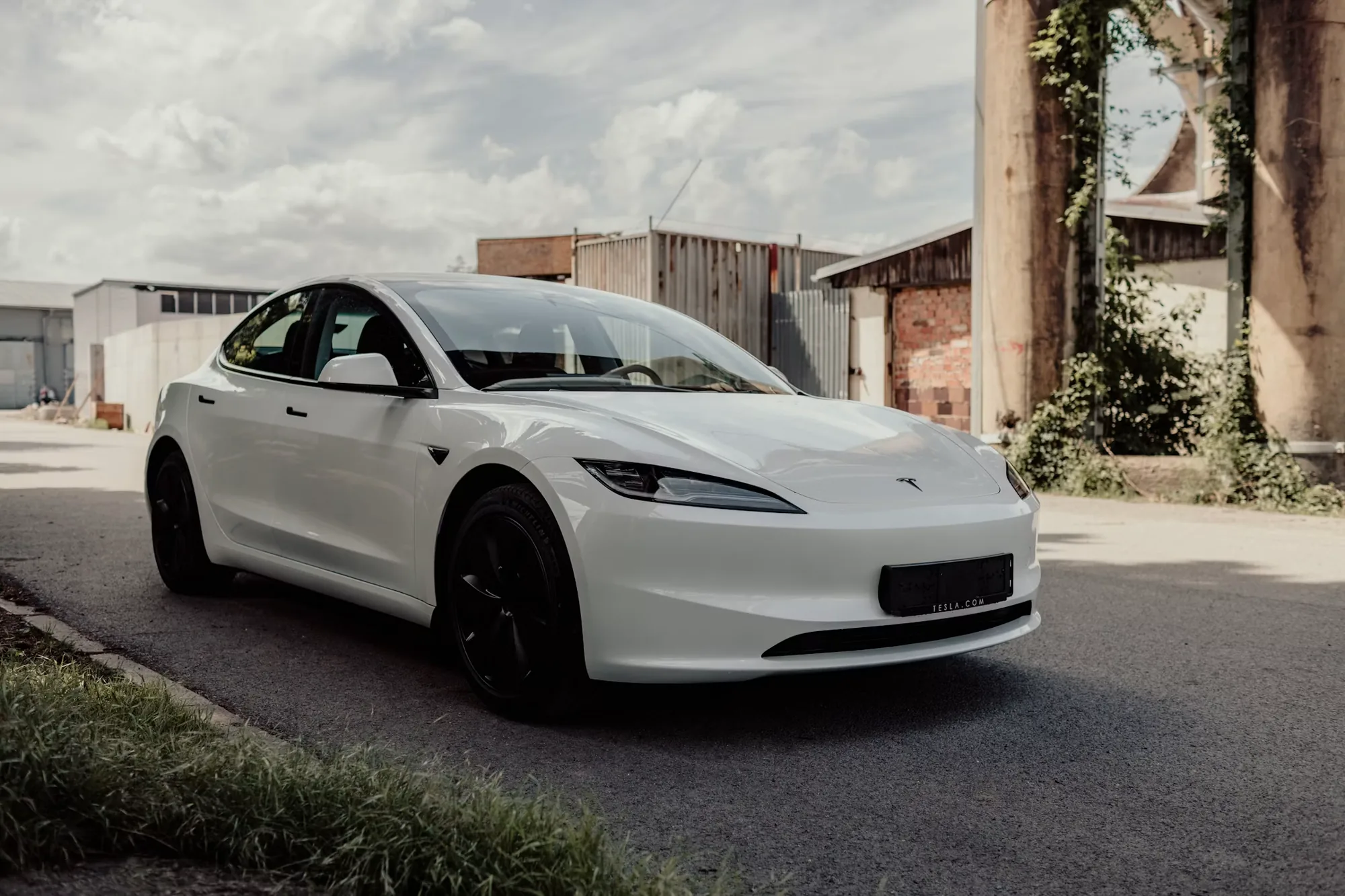 Fehér Tesla Model 3 Highland ipari környezetben