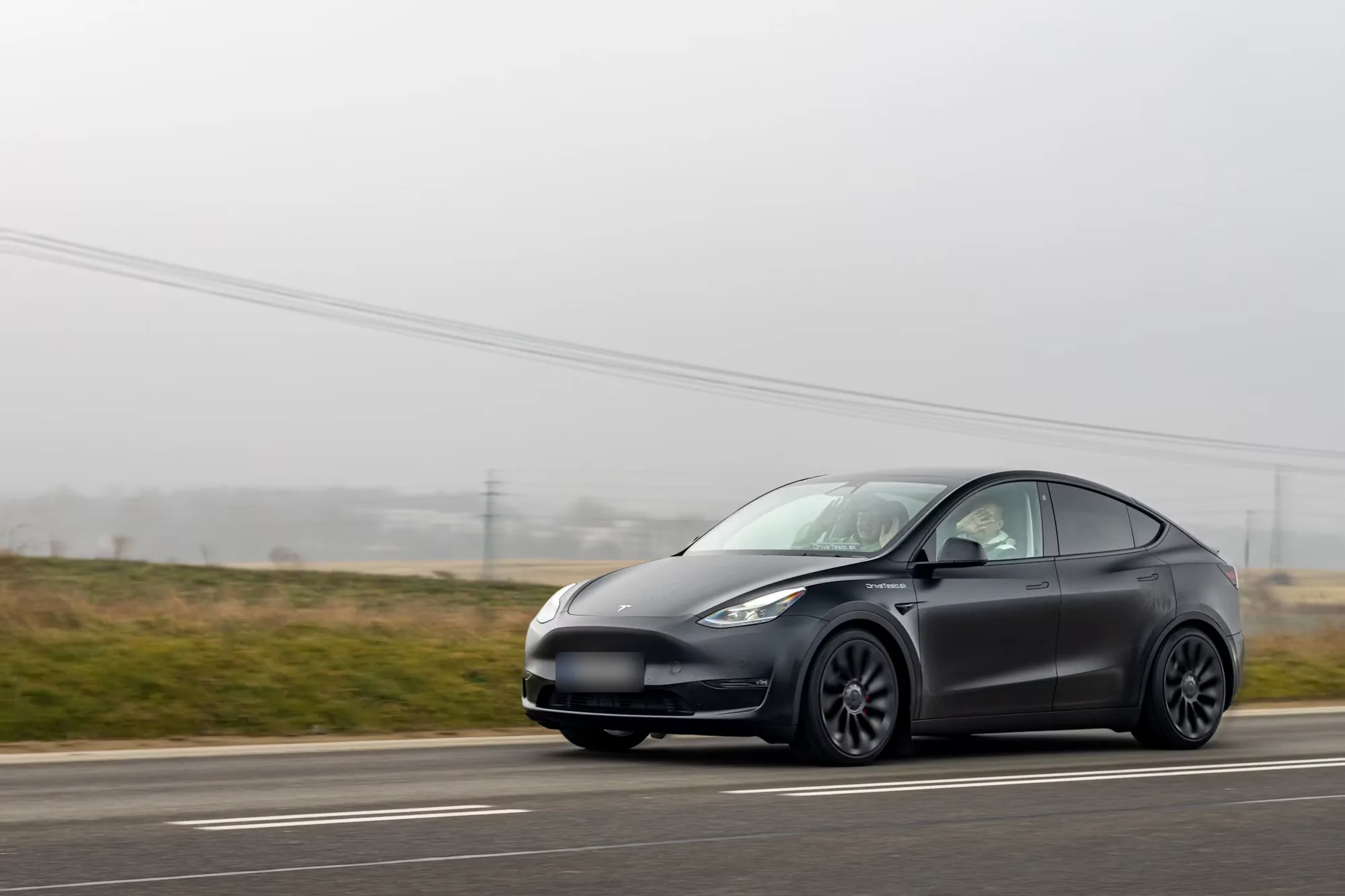 Sötétszürke Tesla Model Y Performance úton
